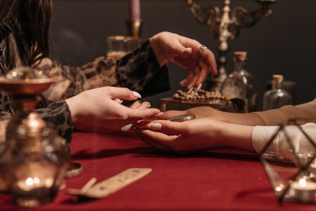 A fortune teller delicately reading a client's palm in a mystic setting with enchanting ambiance.