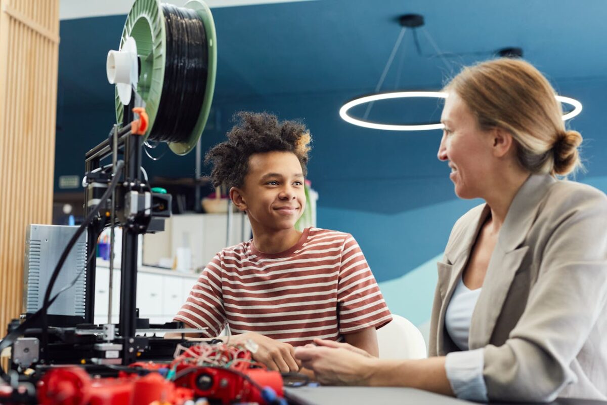 Positive young male engineer sitting at table with woman and working together on project in light room
